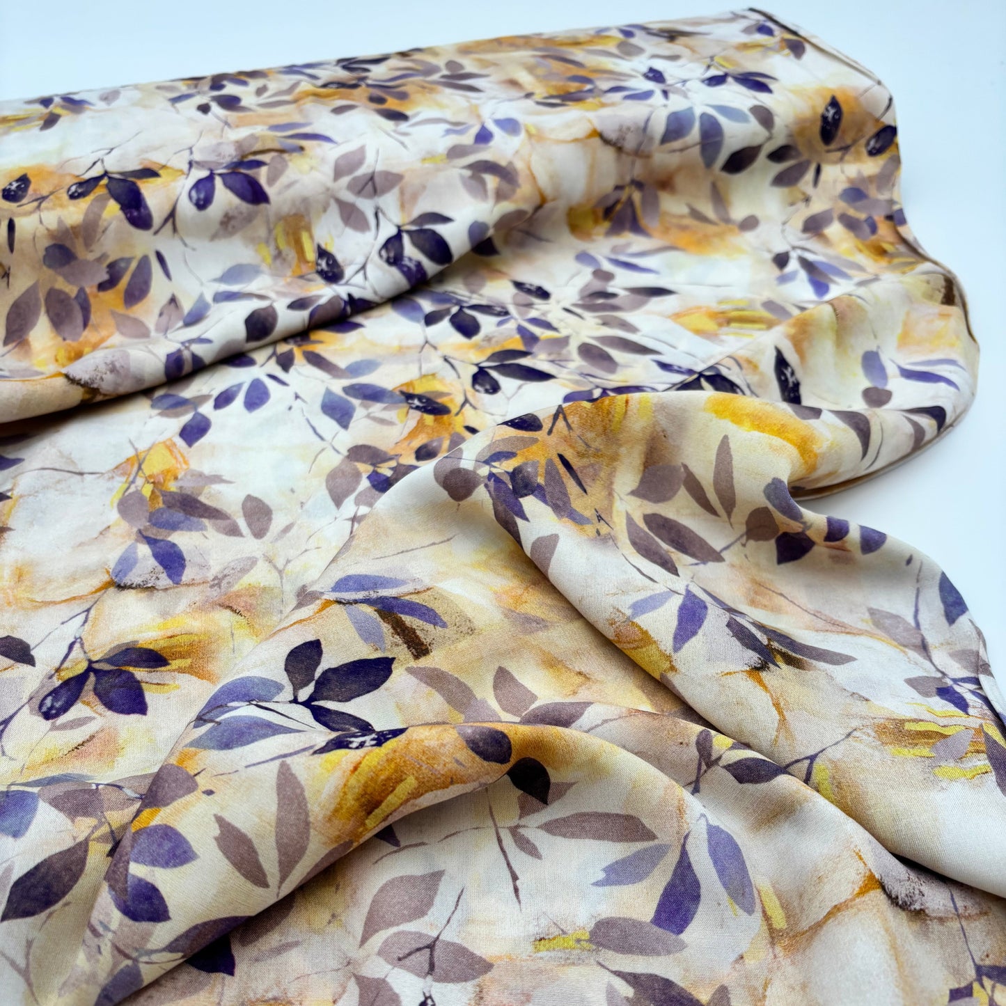 Viskosestoff - Elfenbein mit gelbem und violettem Blätterdesign (Meterware)